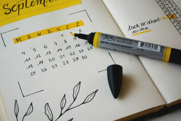 Rotulador negro sobre un cuaderno con un calendario